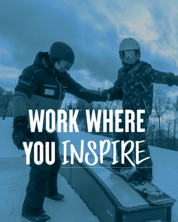 A snowboard instructor helping a young student learn to use a small terrain park feature. Text overlay reads Work Where You Inspire.